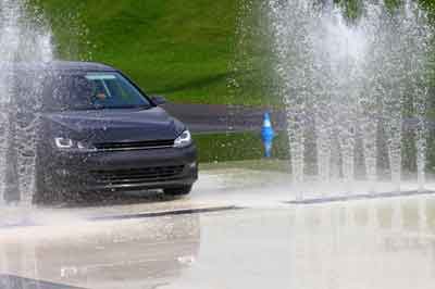 Ein Auto fährt auf nasser Straße während einer Übung des Fahrsicherheitstrainings.