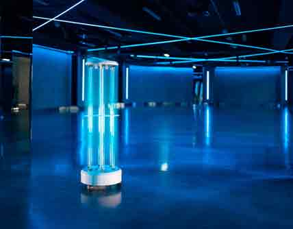 Maschine auf Rollen entfernt Viren mit UV-Licht in einer leeren Halle.