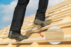 Beschäftigter steht auf keilgezinkte Dachlatten mit Detailbild der Keilzinkung