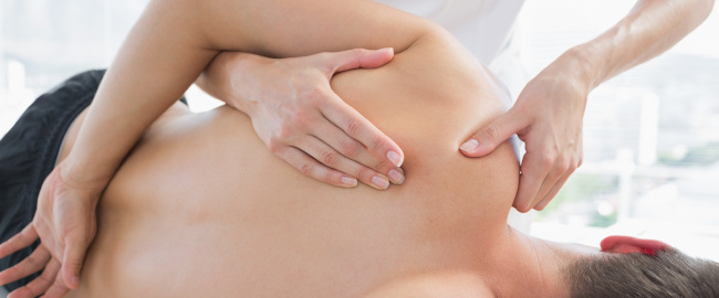 Ein Patient ist bei der Physiotherapie und lässt seine Schulterschmerzen behandeln.