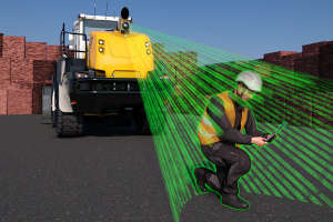 Eine Kamera ist an einem Baufahrzeug angebracht und erkennt einen hockenden Bauarbeiter vor dem Fahrzeug.