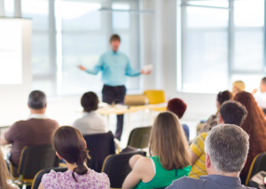 Referent hält vor einem Publikum eine Präsentation.