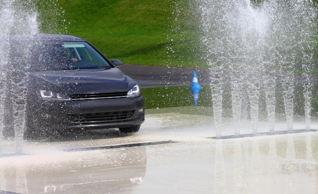 Ein Auto fährt auf nasser Straße während einer Übung des Fahrsicherheitstrainings.