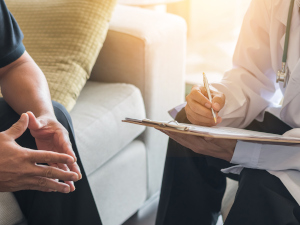 Ein Arzt unterhält sich mit einem Patienten.