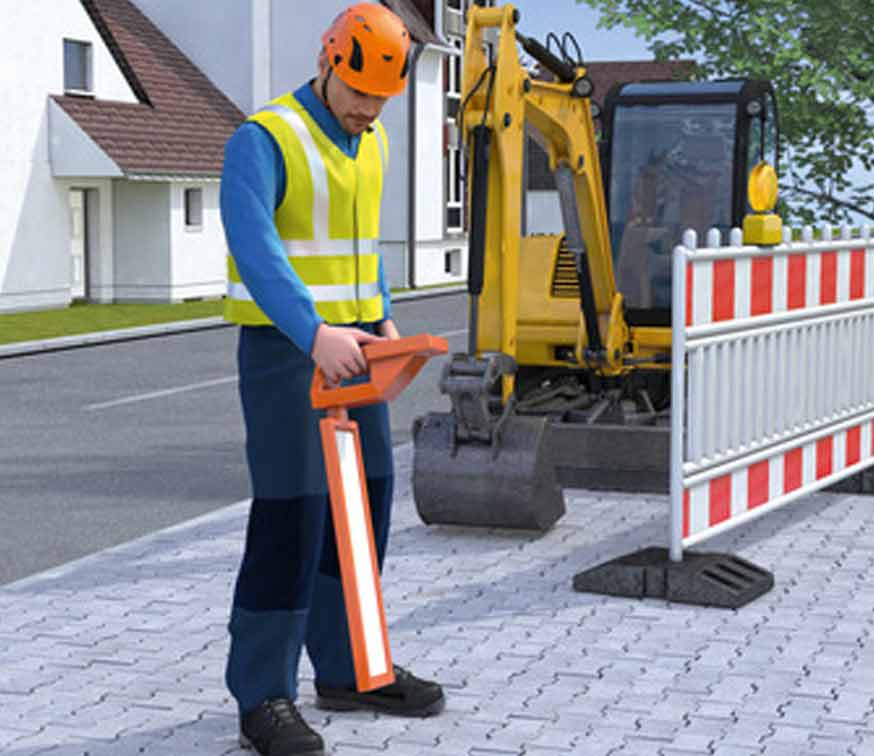 Ein Bauarbeiter mit einem Ortungsgerät zum Auffinden von Leitungen.
