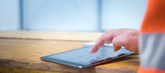 Bauarbeiter nutzt ein Tablet bei der Arbeit.