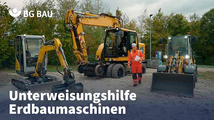 Denny Hillert vor drei Erdbaumaschinen im Sand.