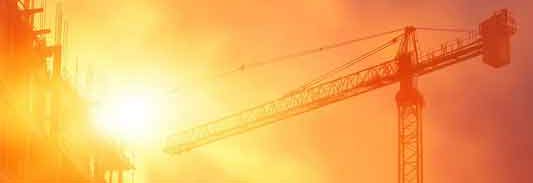 Sonne und brütende Hitze auf einer Baustelle mit einem Kran.